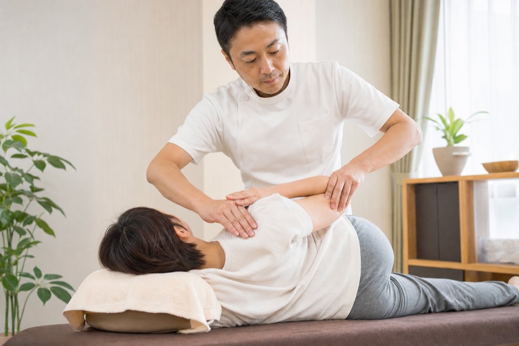 整体院で肩や背中の施術を受ける来院者