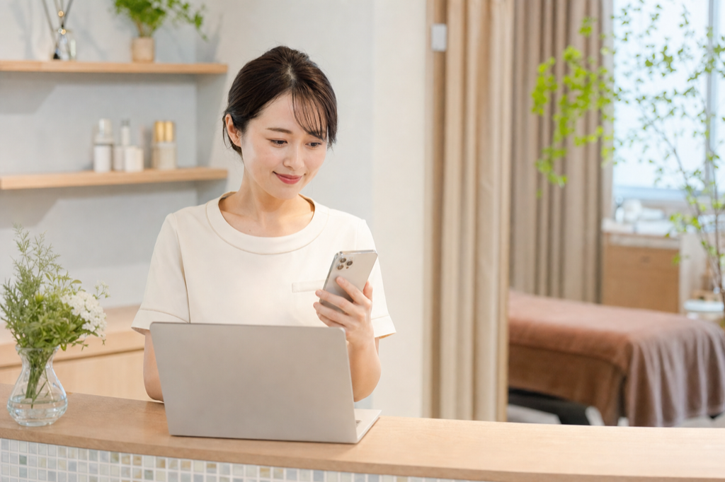 受付で予約状況と集客施策を確認するバストアップサロンオーナー