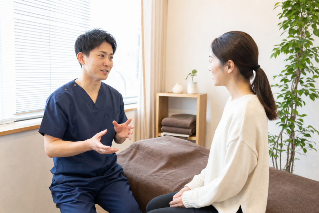 初診患者へ施術内容を丁寧に説明する整体院の院長