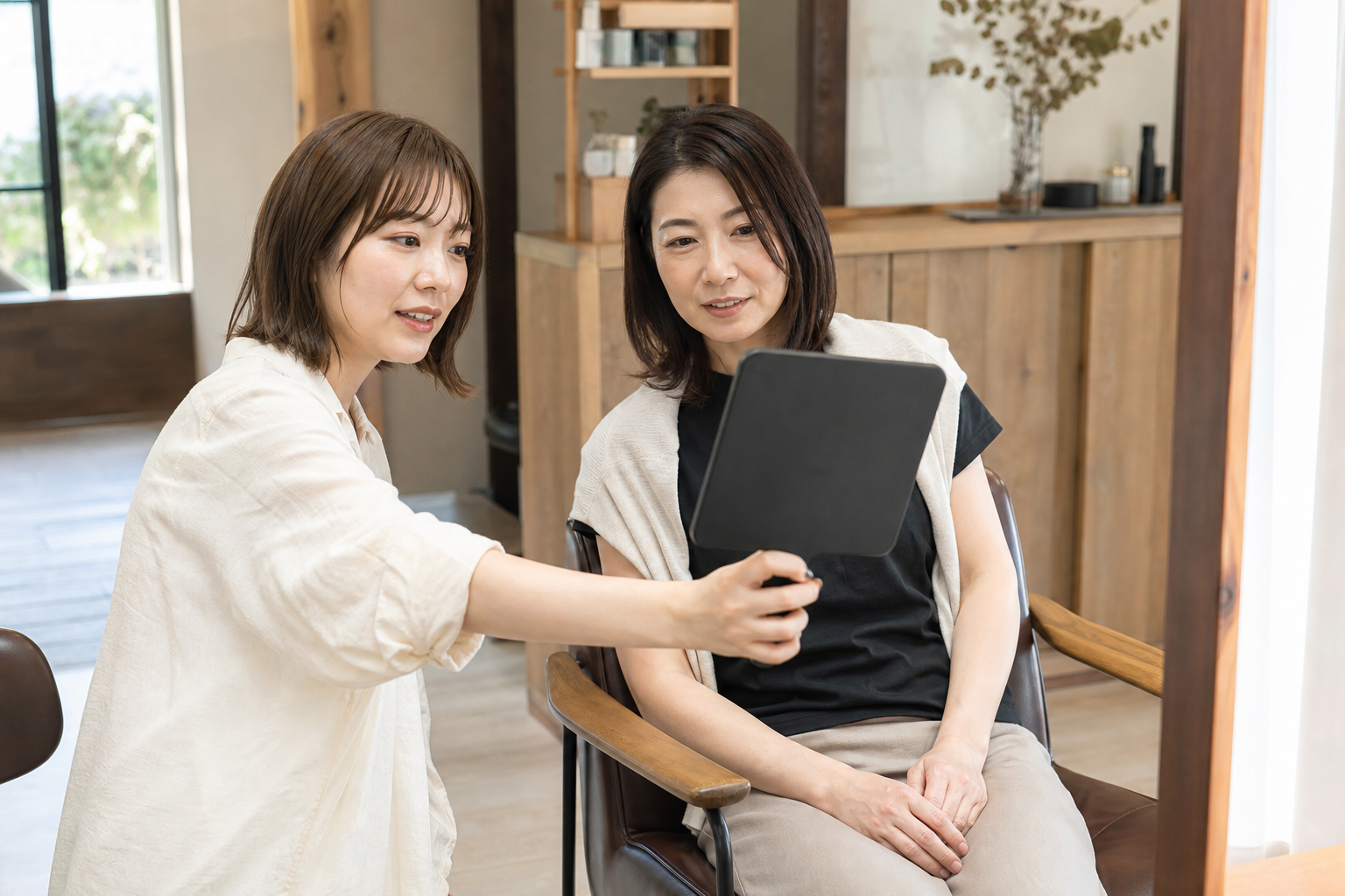 鏡を見ながら髪の悩みを相談する美容師とお客様